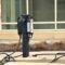 An old fashioned telephone is on the sidewalk