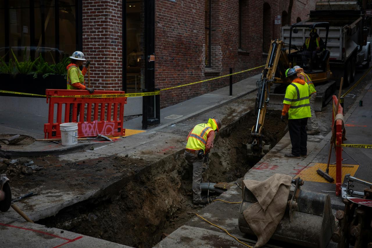 Construction workers digging a trench on a city street