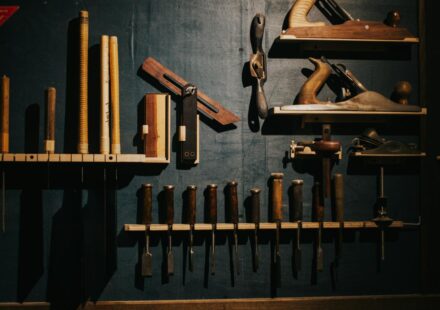 Various woodworking tools neatly arranged on a dark wall