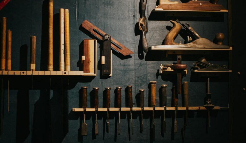 Various woodworking tools neatly arranged on a dark wall