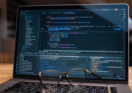 Laptop screen displaying lines of code with glasses