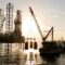 An oil rig being serviced by a supply ship