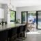 Modern kitchen with large island, bar stools, and outdoor patio